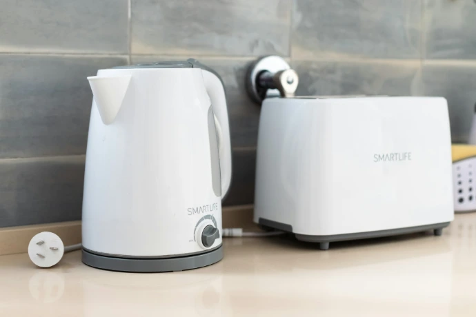 a white toaster next to a white toaster